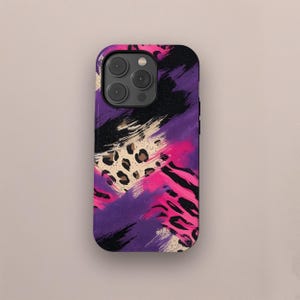 May include: A phone case with a vibrant abstract design. The case features a mix of colors, including purple, pink, black, and tan. The design incorporates brushstrokes, leopard print, and a textured appearance, creating a bold and eye-catching aesthetic.