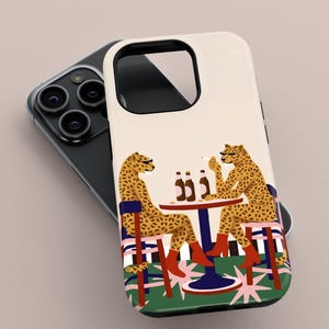 May include: A phone case with a quirky illustration of two cheetahs at a table with bottles and cigarettes. The cheetahs are wearing boots and sitting on chairs. The background has a green and pink design.