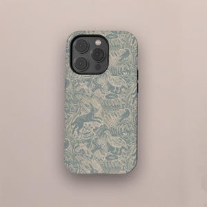 Könnte beinhalten: Eine Handyhülle mit einem Naturmuster. Das Design zeigt einen hellblauen Hintergrund mit Illustrationen von Hasen, Vögeln und Blättern in Creme. Die Hülle hat einen schwarzen Rand und einen Kameraausschnitt.