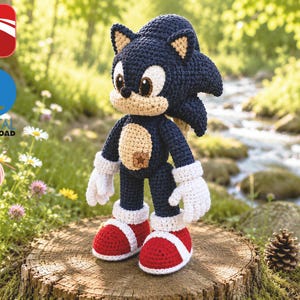 May include: A crochet plush toy of a blue hedgehog character with large white gloves, red and white shoes, and a tan belly patch. The figure features dark blue yarn, a small brown star-shaped detail on the chest, and black eyes with white highlights.