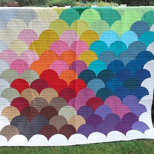 May include: A colorful quilt with a rainbow pattern of half-circle shapes. The quilt is made of different shades of green, yellow, orange, red, brown, purple, and blue.