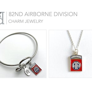 May include: A silver charm bracelet with a silver charm that says "82nd" and a red, white, and blue charm with the 82nd Airborne Division insignia. A silver necklace with a red, white, and blue pendant with the 82nd Airborne Division insignia.