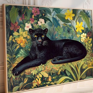Op de afbeelding: Een ingelijste kunstdruk met een zwarte panter die rust te midden van weelderig gebladerte en kleurrijke bloemen. Het kunstwerk toont een gedetailleerde illustratie van de panter met gele ogen, omringd door een levendige junglesc&egrave;ne met groene bladeren en gele, roze en witte bloemen.