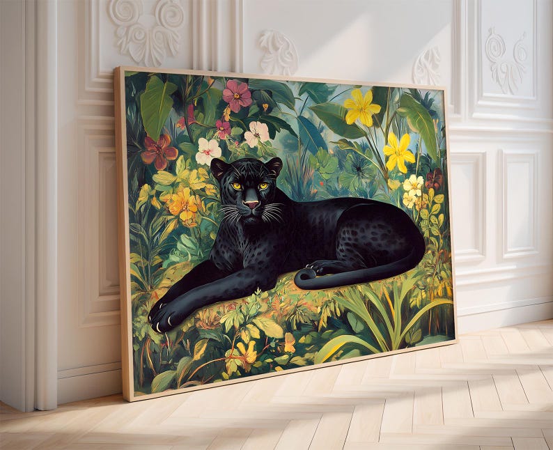 Op de afbeelding: Een ingelijste kunstdruk met een zwarte panter die rust te midden van weelderig gebladerte en kleurrijke bloemen. Het kunstwerk toont een gedetailleerde illustratie van de panter met gele ogen, omringd door een levendige junglesc&egrave;ne met groene bladeren en gele, roze en witte bloemen.