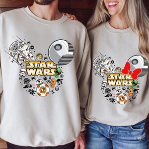 May include: Two gray sweatshirts with a Mickey Mouse ear design featuring Star Wars characters. The design includes a Death Star, X-Wing, Yoda, R2-D2, BB-8, and the text "Star Wars".