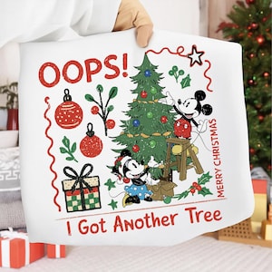 May include: White Christmas-themed pillow with a cartoon illustration of Mickey and Minnie Mouse decorating a Christmas tree. The text "OOPS! I Got Another Tree" and "Merry Christmas" are included in the design. The pillow features red, green, and blue accents.