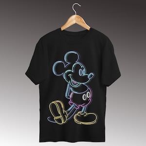 Op de afbeelding: Zwart T-shirt met een neon-stijl illustratie van Mickey Mouse. Het ontwerp gebruikt blauwe, roze, gele en groene contouren om het iconische personage af te beelden. Het shirt hangt aan een houten hanger.
