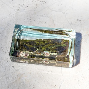 May include: A set of three ceramic mugs with a speckled, matte finish. The mugs are in shades of cream, light gray, and dark gray. Each mug has a simple, minimalist design and a rounded handle.