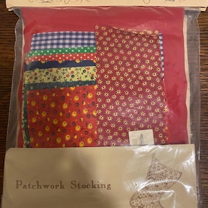 May include: A patchwork stocking kit by Yours Truly. The kit includes a variety of fabric scraps in red, green, blue, yellow, and white with floral and geometric patterns. The kit also includes a pattern for a stocking.