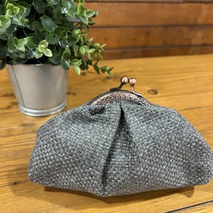 Könnte beinhalten: Set aus drei Keramikbechern mit gesprenkelter, matter Oberfläche. Die Becher sind in Creme-, Hellgrau- und Dunkelgrautönen gehalten. Jeder Becher hat ein schlichtes, minimalistisches Design, ideal für Kaffee oder Tee.