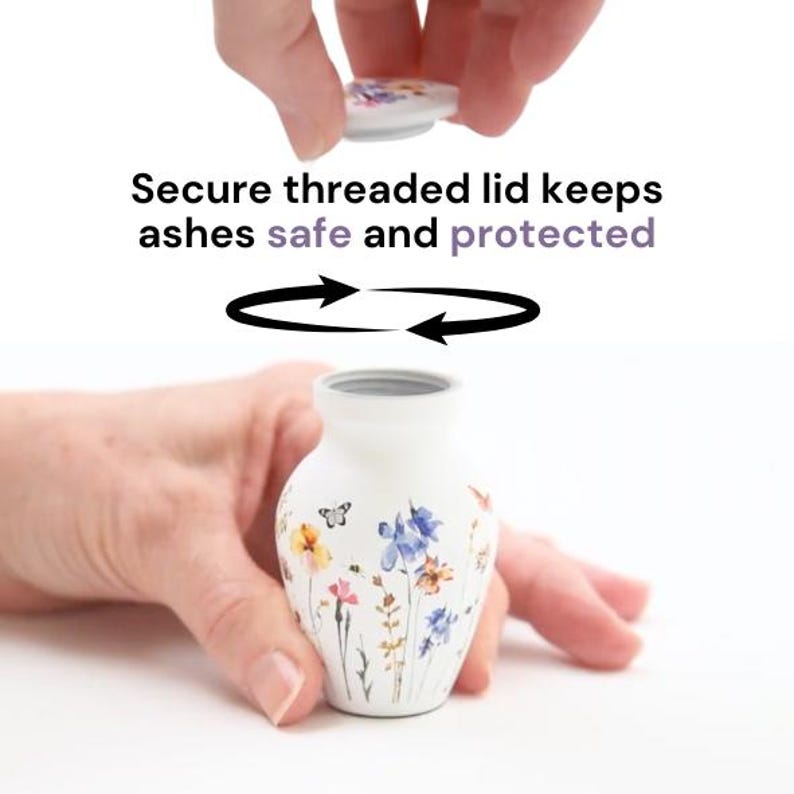 May include: White ceramic urn with a floral design featuring butterflies and flowers. The urn has a threaded lid that screws on to keep ashes safe and protected.