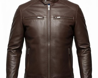 May include: A brown leather jacket with a stand-up collar and a blue lining. The jacket has a zip closure, two chest pockets, and two side pockets. The sleeves are long and fitted.