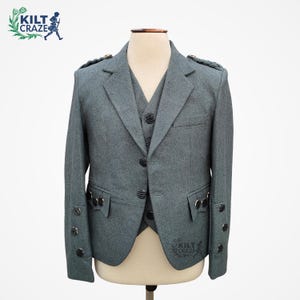 Puede incluir: Conjunto de chaqueta y chaleco de lana gris sobre un maniquí. La chaqueta presenta botones negros, detalles decorativos en los hombros y puños abotonados. El chaleco es visible debajo de la chaqueta. El logotipo de Kilt Craze está arriba a la izquierda y abajo a la derecha.