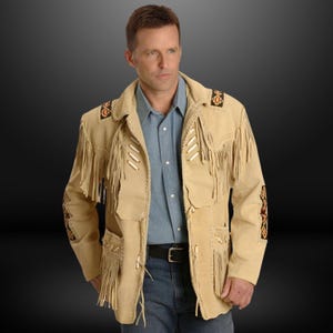May include: Tan suede jacket with fringe detailing, decorative stitching, and bead accents. The jacket features a notched collar, pockets, and a button closure. The sleeves and back have decorative stitching.