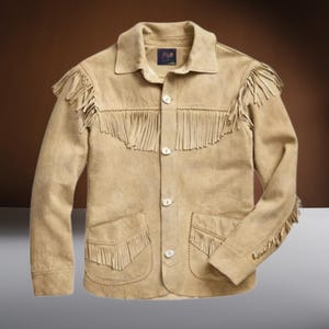 May include: A tan suede jacket with fringe detailing on the collar, pockets, and sleeves. The jacket has a button-up front closure.