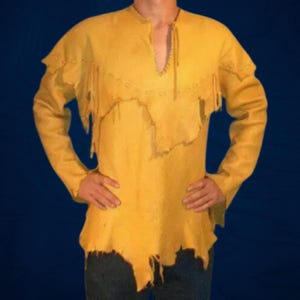 May include: Mustard yellow long-sleeved shirt with a V-neck and fringed detailing. The shirt has a distressed, raw-edge design along the hem and shoulders. The shirt is made of a soft, textured material.