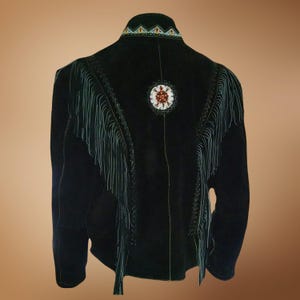 Puede incluir: Chaqueta de ante negro con detalles de flecos y adornos de cuentas. La chaqueta tiene un dise&ntilde;o redondo de cuentas en la espalda.