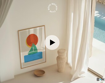 May include: A framed abstract print of a sailboat with a red, yellow, and green sun above it. The print is hanging on a white wall in a room with white curtains and a pool view.