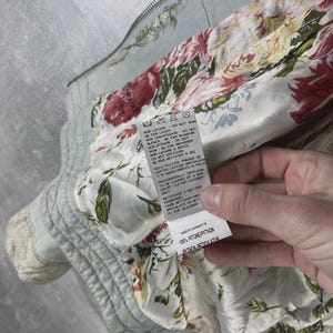 Peut inclure: Veste bleu clair avec un motif floral sur l'ext&eacute;rieur et une doublure &agrave; imprim&eacute; floral vif. La veste a une fermeture &eacute;clair et une &eacute;tiquette avec des instructions d'entretien et la composition du tissu : 100% Python Reticulatus.