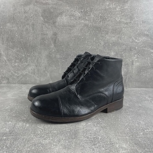 May include: A pair of black leather ankle boots featuring a rounded toe cap, a lace-up front closure with thin black laces, and a low-profile dark brown sole. The boots have a smooth finish with visible stitching details along the sides and heel.