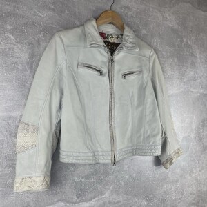 Peut inclure: Veste en cuir gris clair avec fermeture &eacute;clair et deux poches zipp&eacute;es. La veste a un col et des coutures d&eacute;coratives. Les manches pr&eacute;sentent un motif peau de serpent sur les coudes et les poignets. La doublure int&eacute;rieure a un motif floral.