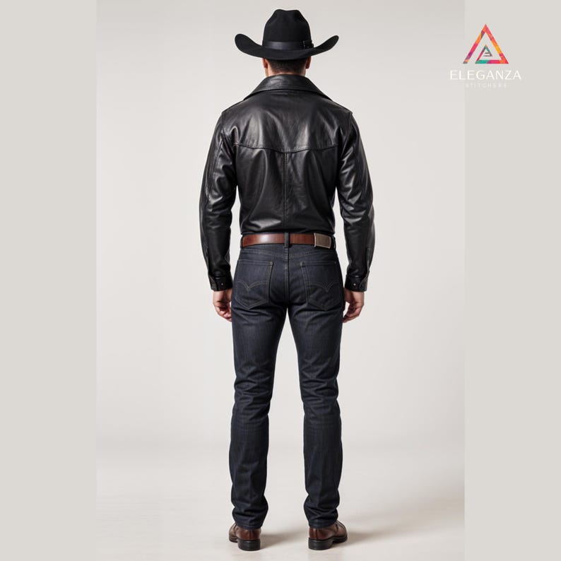 May include: A black leather jacket, dark wash jeans, and a black cowboy hat. The jacket has a button-down front and a brown belt. The outfit is completed with brown leather boots. The Elegenza logo is in the upper right corner.