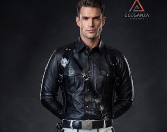 May include: A black long-sleeved shirt with a button-down front and two chest pockets, worn under a black leather-style harness with silver buckles and studs. The outfit includes a black belt with a silver buckle and light-colored trousers.