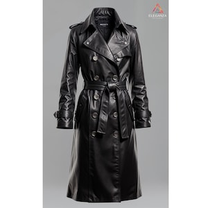 May include: A black leather trench coat with a double-breasted closure, a belt, and a collar. The coat has two pockets on the front and a logo on the inside of the collar that says "MEGAN."
