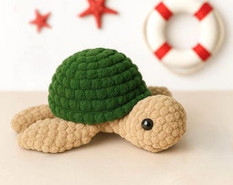 May include: A crochet turtle toy featuring a dark green textured shell and a light tan body with a smooth, rounded head and black plastic eyes. The turtle is positioned in front of two small red starfish and a white and red life preserver ring.
