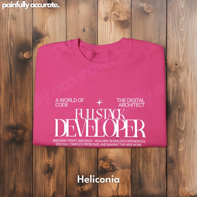 A pink t-shirt with white text is displayed on a wooden background.