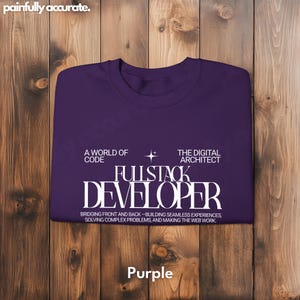 Purple T-shirt with white text on a wooden background.
