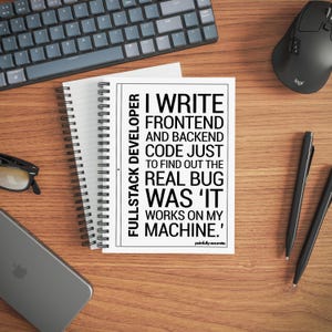 Könnte beinhalten: Ein weißer Notizblock mit dem Text "Ich schreibe Frontend- und Backend-Code nur, um den eigentlichen Fehler herauszufinden, war 'es funktioniert auf meinem Rechner'" liegt auf einem Holztisch. Eine Tastatur, eine Maus, Stifte, eine Brille und ein Telefon befinden sich ebenfalls auf dem Tisch.