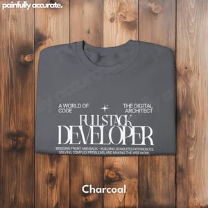 A gray t-shirt with white text and a star graphic, laid out on a wooden surface.