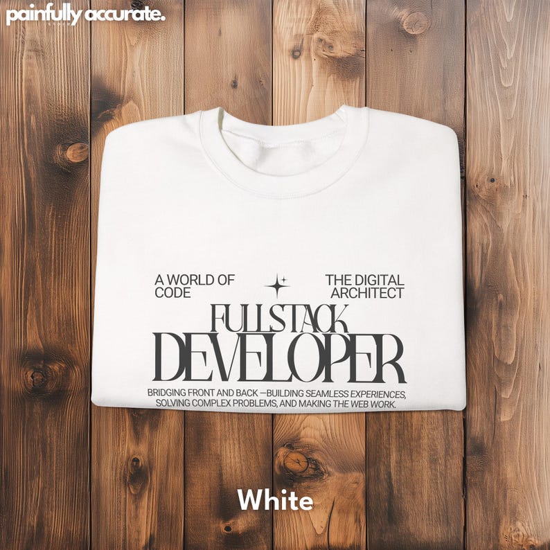 A white t-shirt with text printed on it, laid out on a wooden surface.