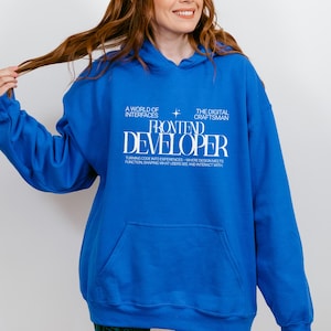 May include: A bright blue hooded sweatshirt featuring white text that reads A WORLD OF INTERFACES, THE DIGITAL CRAFTSMAN, FRONTEND DEVELOPER, and TURNING CODE INTO EXPERIENCES—WHERE DESIGN MEETS FUNCTION, SHAPING WHAT USERS SEE AND INTERACT WITH.