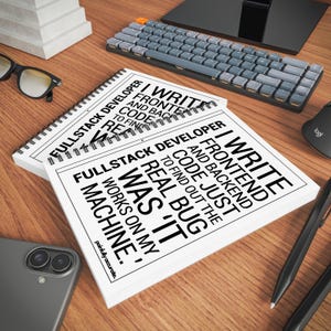 a wooden desk with various office supplies and a spiral notebook titled "Full Stack Developer" lying on top of it.