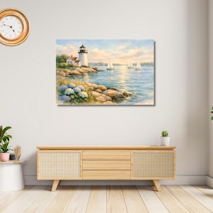 May include: Watercolor painting of a coastal scene featuring a lighthouse, sailboats, and blue hydrangeas. The artwork depicts a serene seascape with a lighthouse on a rocky shore under a blue sky. The painting is displayed above a wooden cabinet.