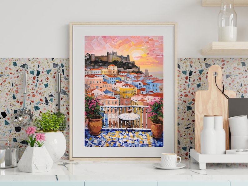 K&ouml;nnte beinhalten: Ein gerahmter Kunstdruck mit einem &Ouml;lgem&auml;lde einer mediterranen Stadt am Hang bei Sonnenuntergang. Die Szene zeigt eine Burg auf einem H&uuml;gel mit Blick auf bunte Geb&auml;ude, einen Balkon mit einem kleinen Tisch, zwei Topfpflanzen und einen gefliesten Boden.