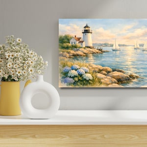 May include: A coastal landscape painting featuring a white lighthouse with a black top, a small house, and sailboats on the water. The scene includes rocks, blue hydrangeas, and a yellow and white vase with flowers.