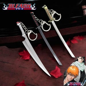 May include: Three silver and gold-colored swords with black and red accents, attached to keychains. The swords are displayed on a dark wooden surface with red flower petals. The image also includes a cartoon image of two characters from the anime Bleach, with the text "BLEACH" in the bottom right corner.