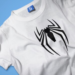 May include: White t-shirt with a black spider-man logo printed on the front.