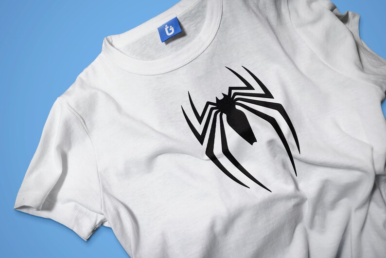 May include: White t-shirt with a black spider-man logo printed on the front.