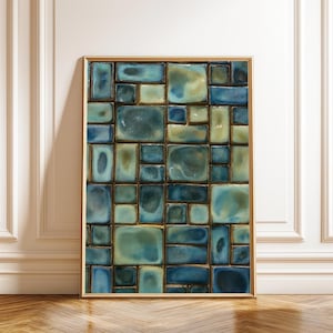 Può includere: Opera d'arte incorniciata con un design a mosaico di piastrelle rettangolari blu e verdi. Le piastrelle variano per dimensioni e tonalità, creando un motivo astratto strutturato. La cornice è dorata e l'opera è esposta contro un muro bianco.