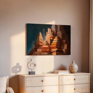May include: An artistic canvas print depicts a cityscape constructed from stacks of books. The artwork features warm, earthy tones with a dark blue background, creating a unique and imaginative scene. The books vary in size and color, adding depth to the composition.