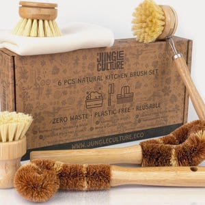 May include: A set of six natural kitchen brushes in a cardboard box. The brushes are made of bamboo, coconut fibre, and hemp. The box has a brown and white design with the text "Jungle Culture" and "6 PCS NATURAL KITCHEN BRUSH SET".