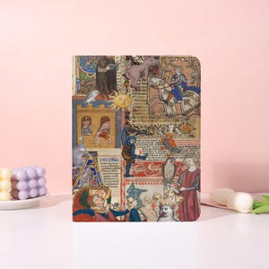 May include: A rectangular notebook featuring a collage of medieval illustrations. The cover displays various scenes with figures, animals, and text in a vibrant, multi-colored design. The notebook is set against a pink background.