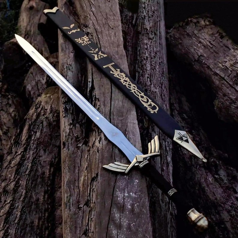 Pu&ograve; includere: Una spada con lama argentata, elsa dorata e manico nero &egrave; appoggiata su una superficie di legno. Un fodero nero con motivi decorativi dorati &egrave; dietro la spada. La spada ha un design dettagliato.