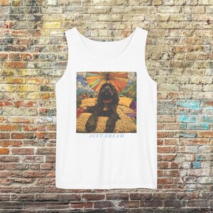 May include: White vest top with a colourful illustration of a black dog under a rainbow umbrella, resting on a bed. The text "JUST DREAM" is printed below the image. The vest top is made of a soft, breathable material.