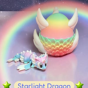 May include: A Starlight Dragon figurine with a rainbow gradient design. The dragon features white wings and a detailed body in shades of blue, pink, and purple. The text "Starlight Dragon" is displayed below the figurine.