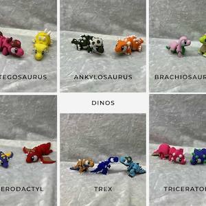 May include: A collection of colorful dinosaur figurines, including Stegosaurus, Ankylosaurus, Brachiosaurus, Pterodactyl, Trex, and Triceratops. Each dinosaur is a different color, with the names of the dinosaurs written below them.